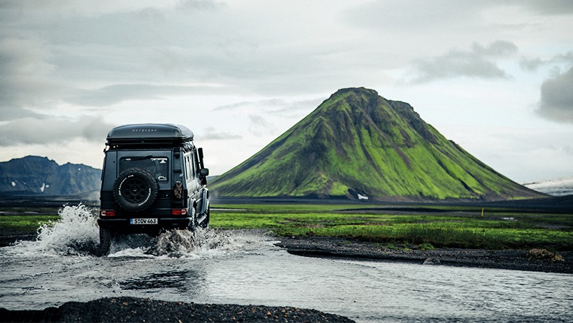 Véhicule tout-terrain équipé d’une tente de toit Autohome en expédition offroad traversée rivière montagne aventure
