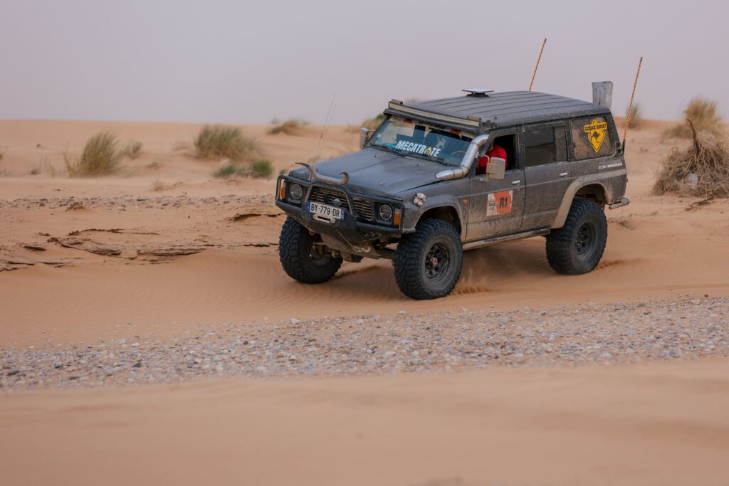 Nissan Patrol noir préparé Mecatrote attaquant une dune de sable – exposant Provence Overland Festival 2026